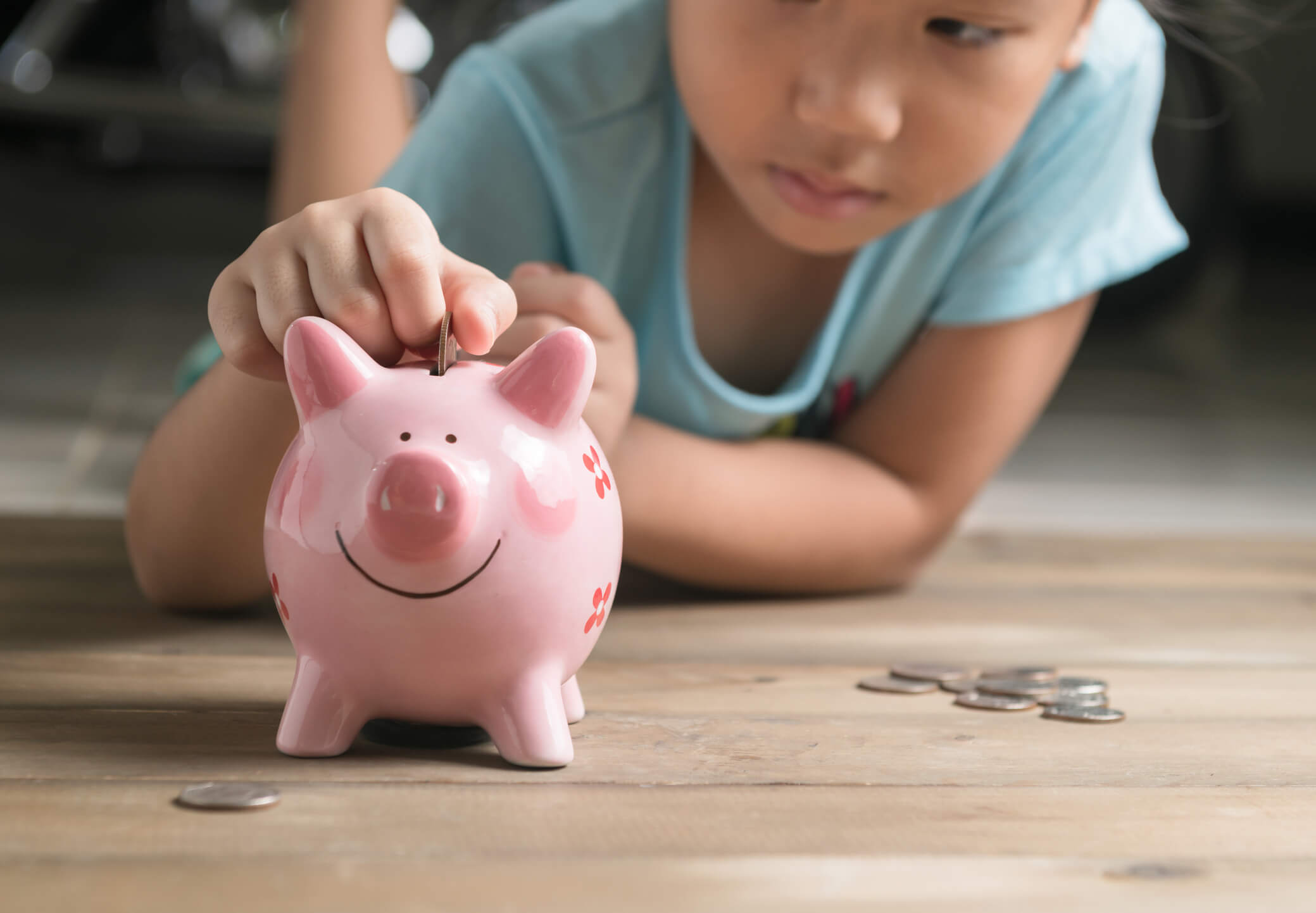 Child Putting Money in a Piggybank