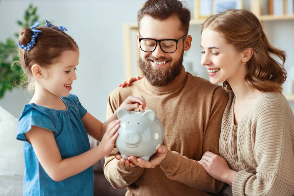 Family putting money in a piggy bank